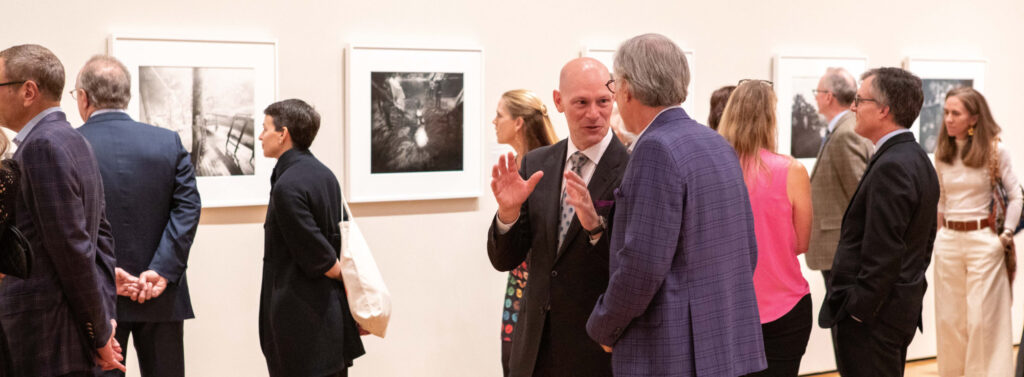 People enjoy an opening night in the Sally Mann exhibition galleries.
