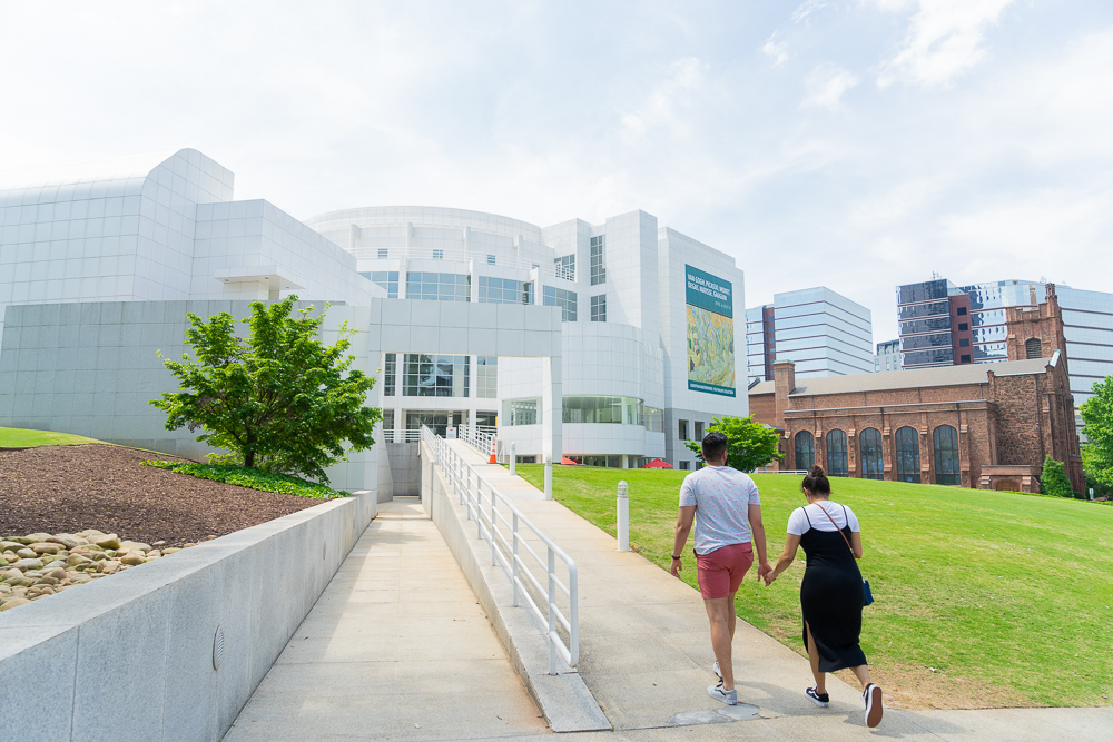 A man and a woman walk up the ramp to the entrance to the High Museum's Richard Meier Building.