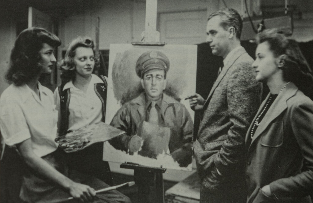 Historical photograph of three women and one man surrounding a painting on an easel
