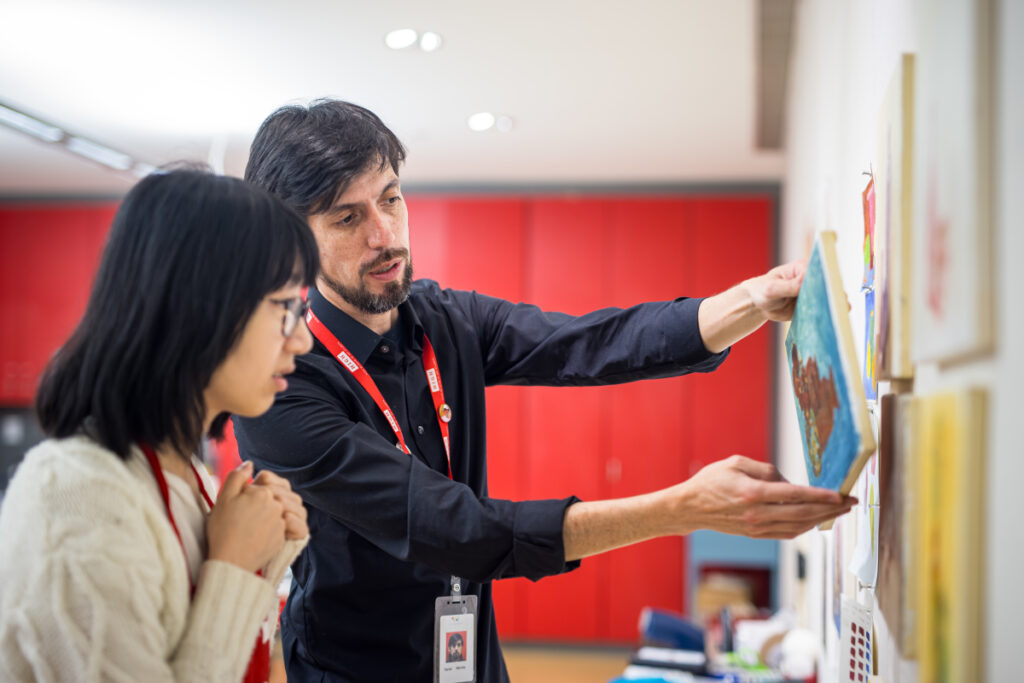 A teaching instructor discussing an artwork with a student.